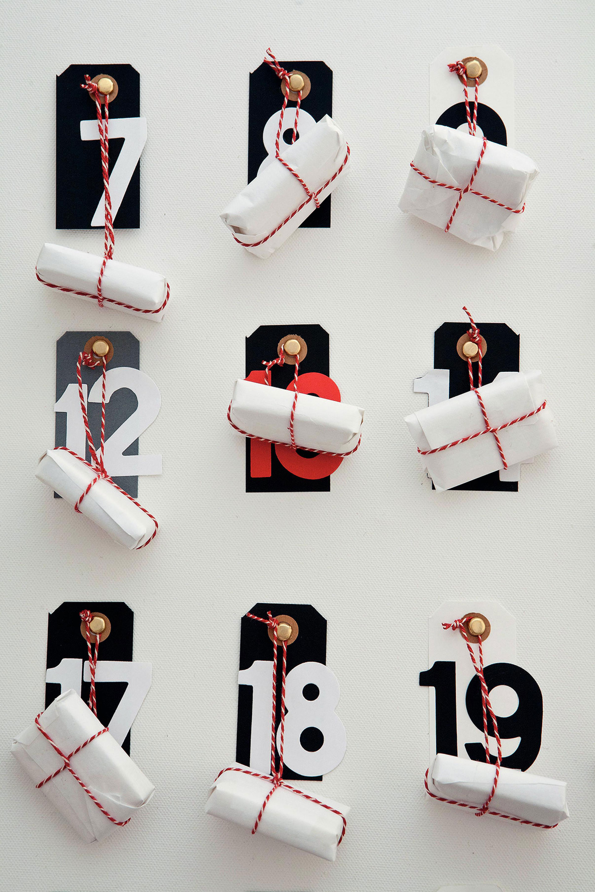 Bild von einem Adventskalender an der Wand mit großen Nummern und eingepackten Geschenken
