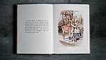 Aufgeschlagenes Buch mit Text und Illustration aus Alice im Wunderland