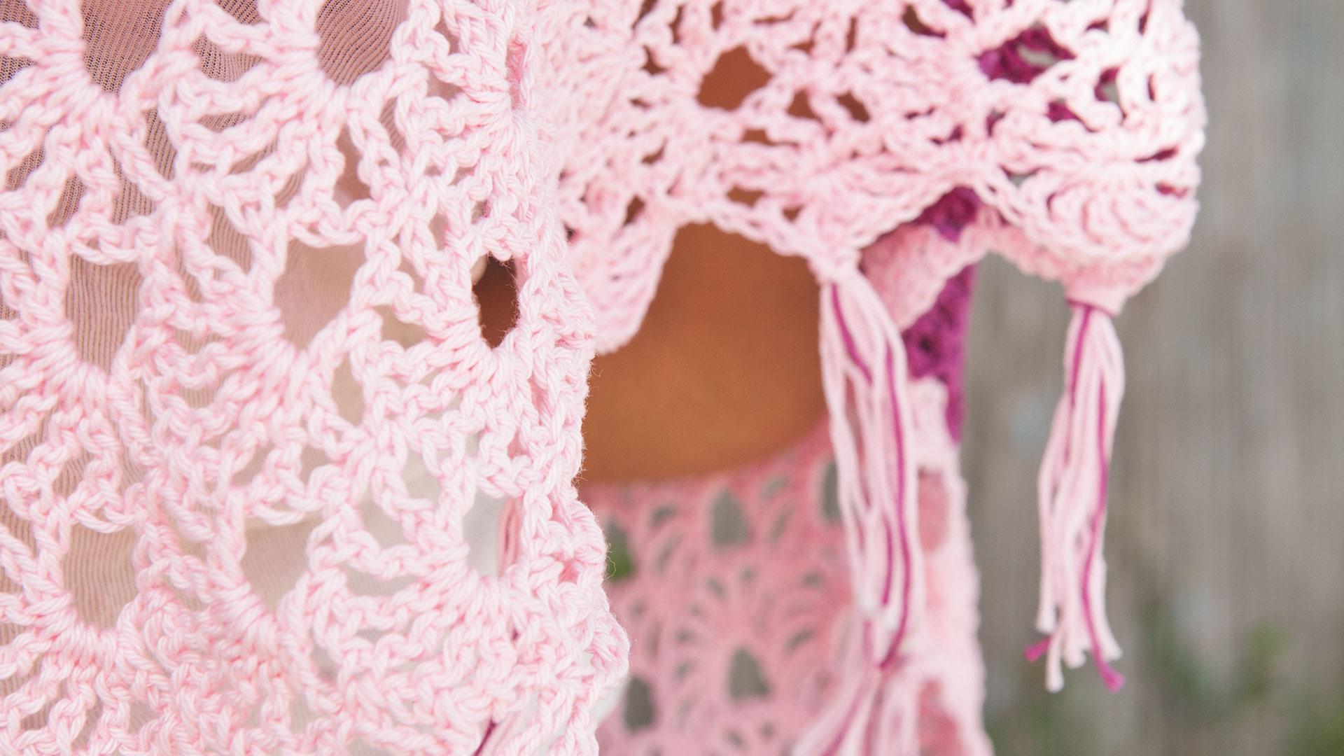 Detailaufnahme rosaner Häkelponcho