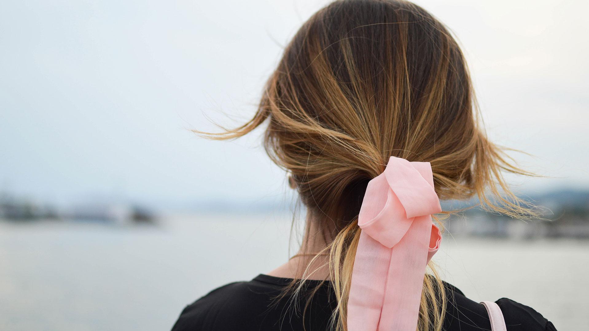 Frau mit rosaner Schleife im Haar