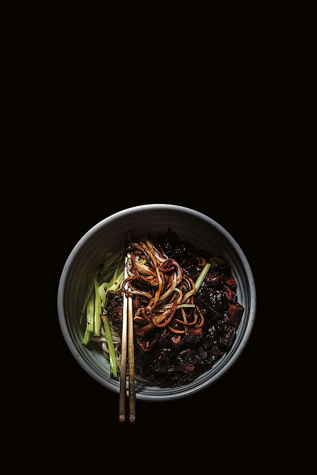 Nudeln mit schwarzer Bohnensauce auf schwarzem Hintergrund