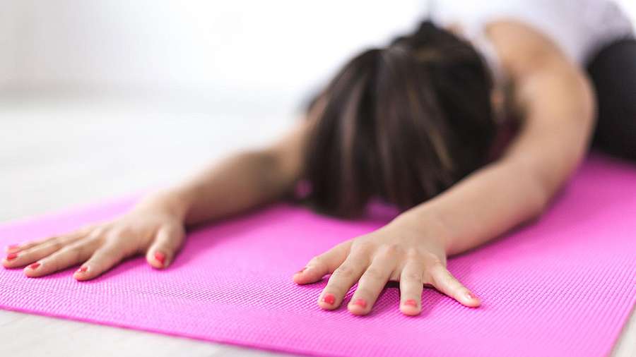 Frau in Child's Pose auf Yogamatte