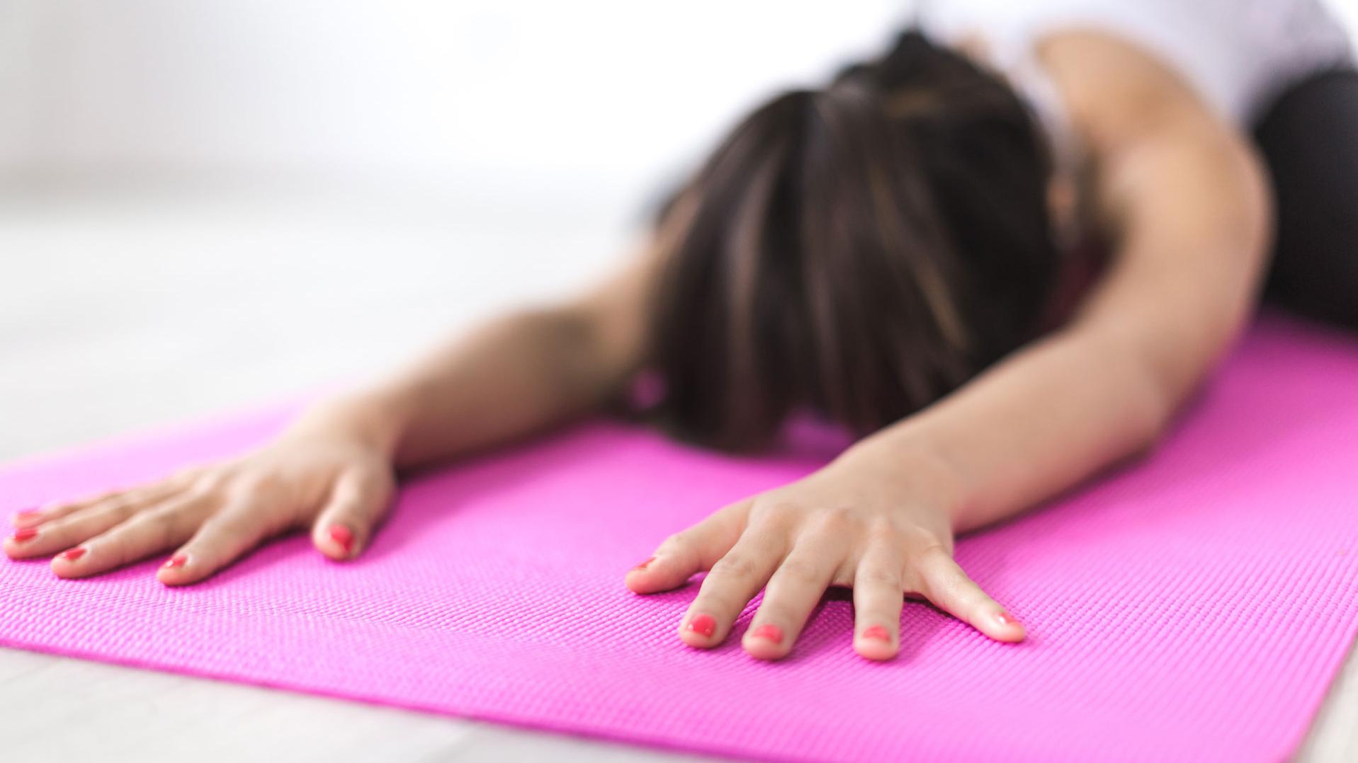 Frau in Child's Pose auf Yogamatte
