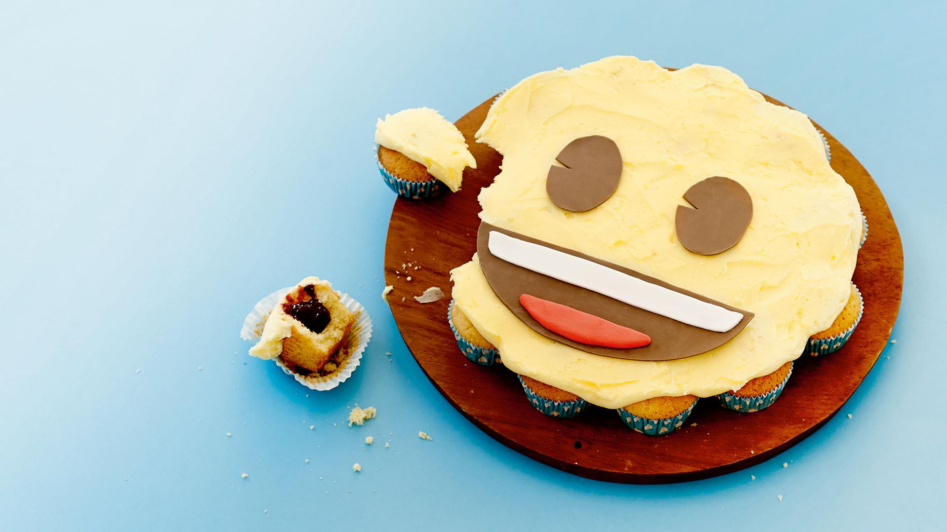 Ein riesiger Emoji, der aus ganz vielen Muffins besteht