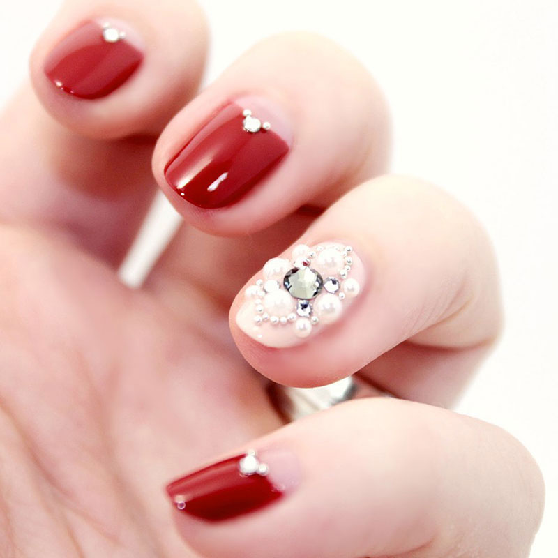 Rote Accent Nails mit weißen Perlen und silbernen Swarovski Steinchen 