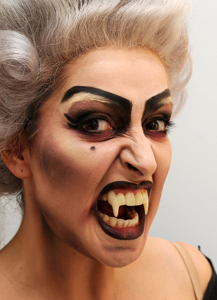 Bild von einer Frau, die als Vampir geschminkt ist und eine graue Perücke trägt