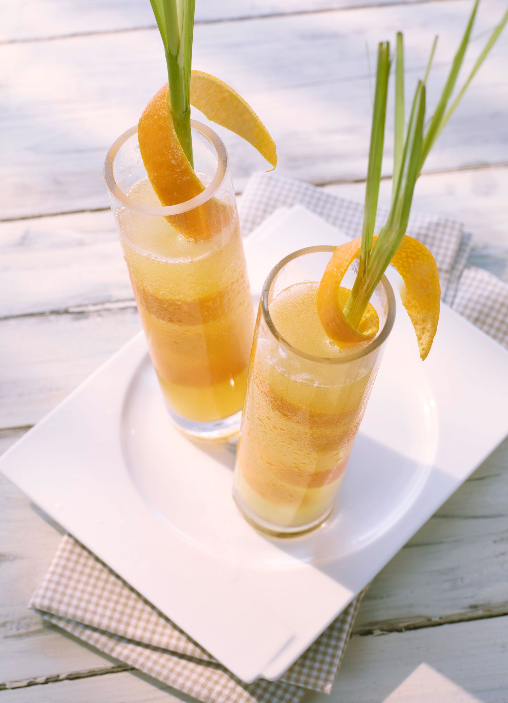 Mineralwasser-Cocktail in Gläsern dekoriert mit Orangenschalen und Zitronengras