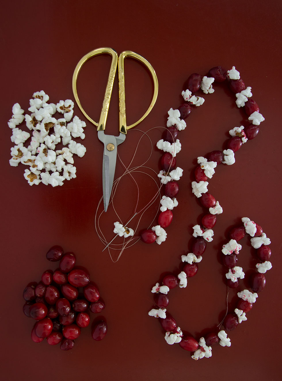Cranberry und Popcorn zu einer Kette aufgefädelt