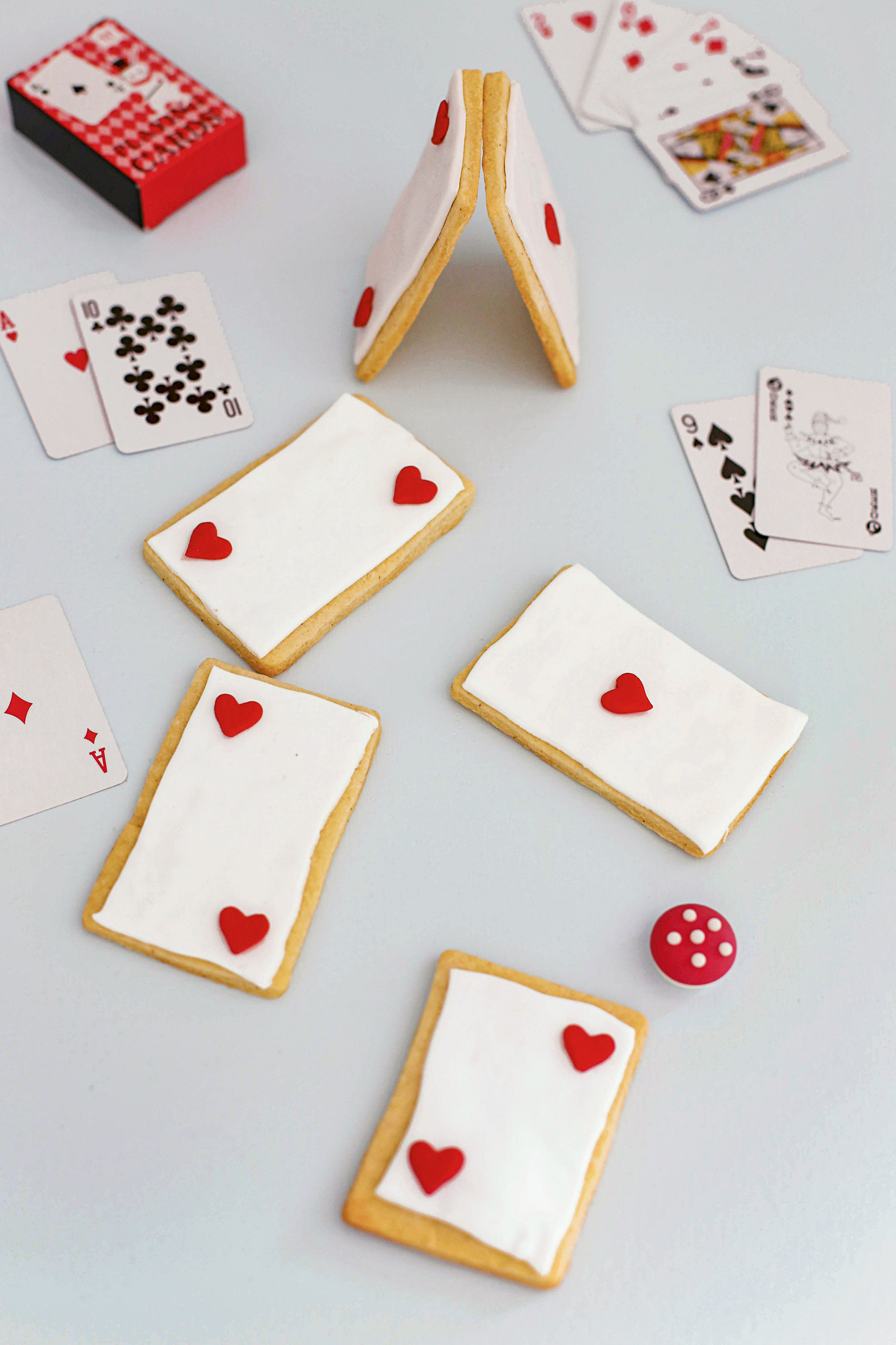 Selbstgebackene Kekse in Spielkartenform mit weißem Fondant und roten Zuckerherzen
