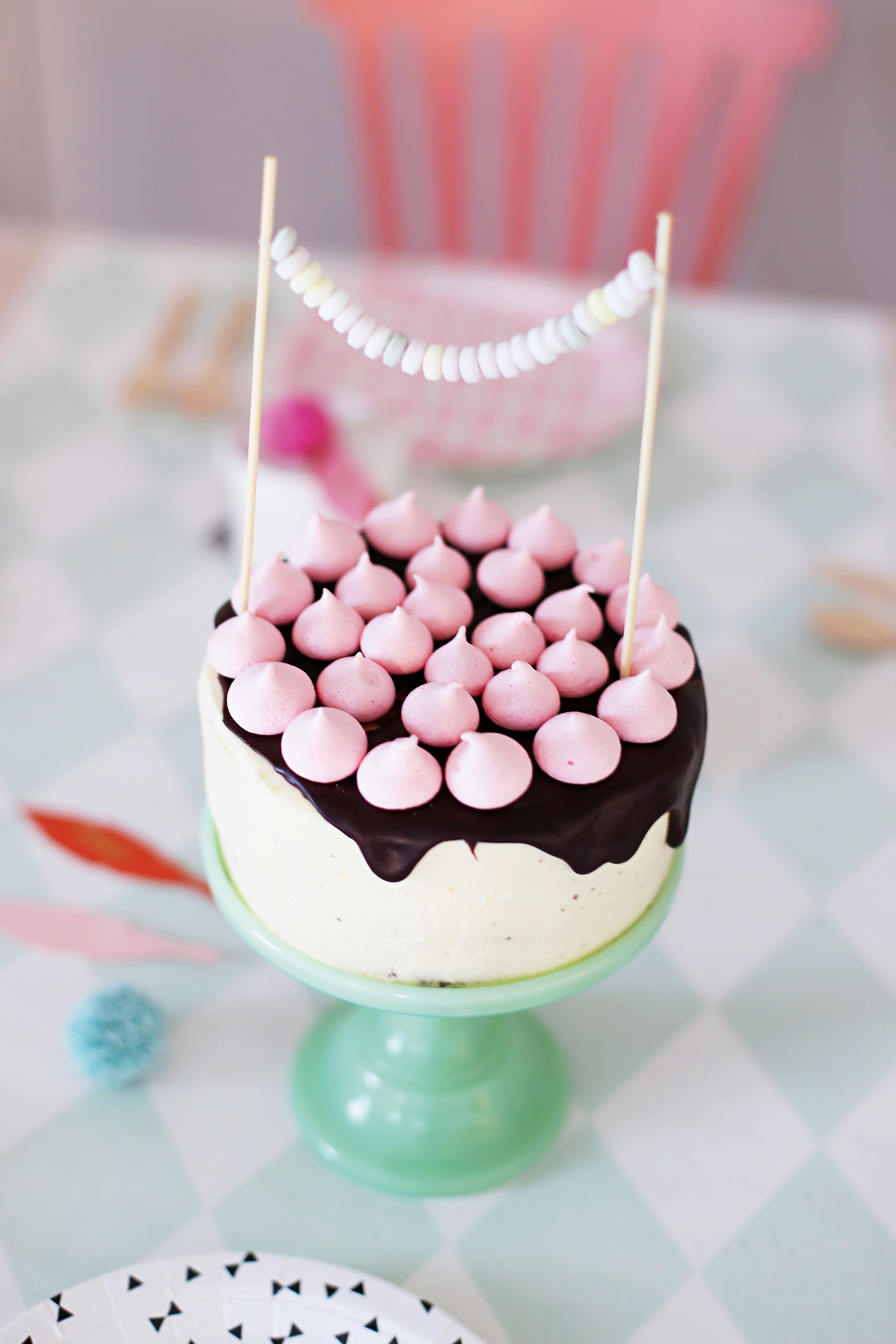 Biskuit-Torte mit Mascarpone-Schokoladencreme und rosafarbenen Baiser-Tupfen.
