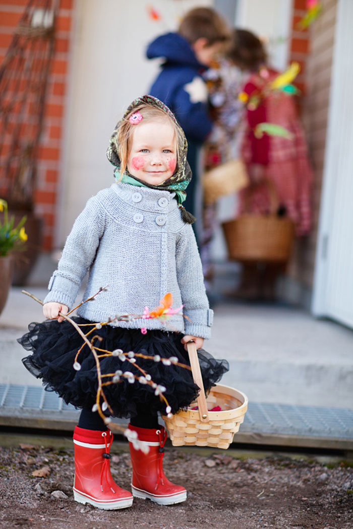 Bild von einem finnischen Mädchen, das zu Ostern als Hexe verkleidet ist