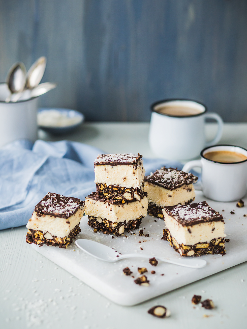 Dessert-Schnitten mit drei Schichten: Keks-Nuss-Boden, Creme und Schokolade