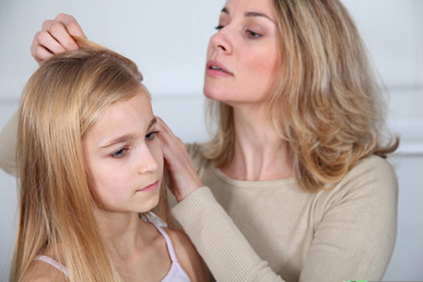 Mutter untersucht die Kopfhaut ihrer Tochter